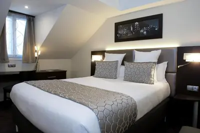 Un ou plusieurs lits dans un hébergement de l'établissement Hotel Choiseul Opera
