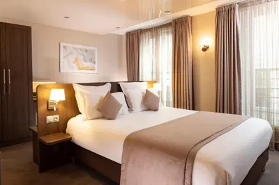 Un ou plusieurs lits dans un hébergement de l'établissement Hotel Choiseul Opera