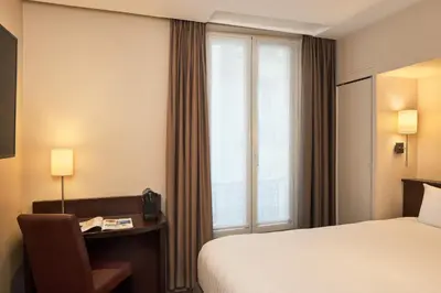 Un ou plusieurs lits dans un hébergement de l'établissement Timhotel Odessa Montparnasse