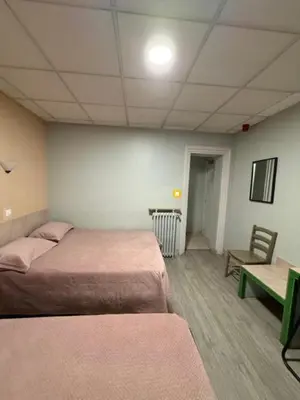 Un ou plusieurs lits dans un hébergement de l'établissement Hôtel Jarry Confort