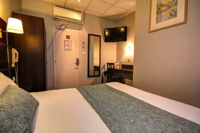 Un ou plusieurs lits dans un hébergement de l'établissement Hôtel Des Trois Gares