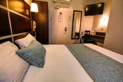 Un ou plusieurs lits dans un hébergement de l'établissement Hôtel Des Trois Gares