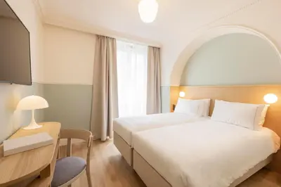 Un ou plusieurs lits dans un hébergement de l'établissement Hôtel Oratio
