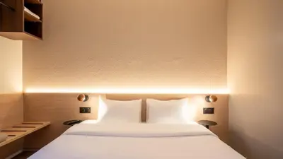 Un ou plusieurs lits dans un hébergement de l'établissement Kyriad ECO - Suresnes - La Defense