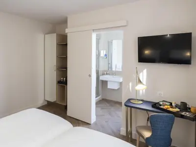 Télévision ou salle de divertissement dans l'établissement Mercure Paris Opera Lafayette