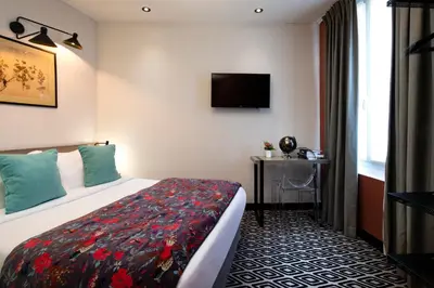 Un ou plusieurs lits dans un hébergement de l'établissement Hôtel Maxim Quartier Latin