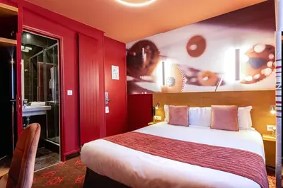 Un ou plusieurs lits dans un hébergement de l'établissement Hotel Ariane Montparnasse by Patrick Hayat