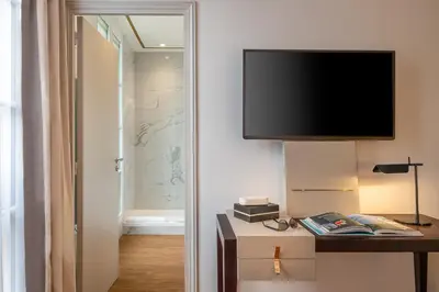 Télévision ou salle de divertissement dans l'établissement Hôtel Le Walt by Inwood Hotels