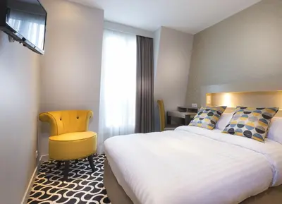 Un ou plusieurs lits dans un hébergement de l'établissement Hôtel International Paris