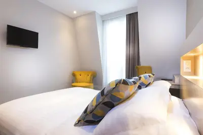 Un ou plusieurs lits dans un hébergement de l'établissement Hôtel International Paris