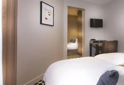 Un ou plusieurs lits dans un hébergement de l'établissement Hôtel International Paris