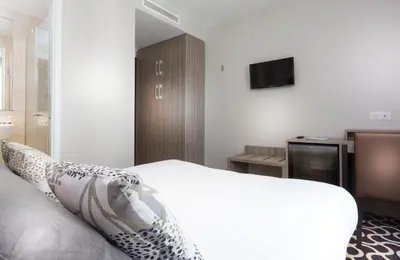 Un ou plusieurs lits dans un hébergement de l'établissement Hôtel International Paris