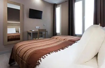 Un ou plusieurs lits dans un hébergement de l'établissement Hôtel des Pavillons