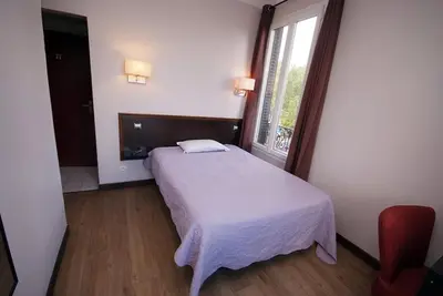 Un ou plusieurs lits dans un hébergement de l'établissement Hôtel Le Bellevue - Paris Porte d'Orléans