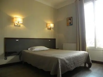 Un ou plusieurs lits dans un hébergement de l'établissement Hôtel Le Bellevue - Paris Porte d'Orléans
