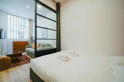 Un ou plusieurs lits dans un hébergement de l'établissement Parisuites Central Canal Saint Martin Design & Luxe & Cosy