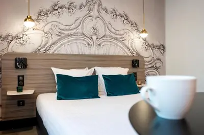 Un ou plusieurs lits dans un hébergement de l'établissement Nemea Appart Hotel Paris Levallois