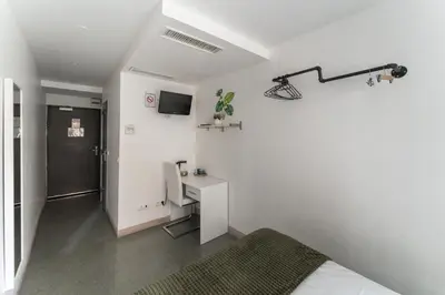 Télévision ou salle de divertissement dans l'établissement L'Oasis Montparnasse