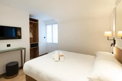 Un ou plusieurs lits dans un hébergement de l'établissement HOTEL AU COEUR DE REPUBLIQUE