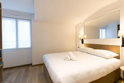 Un ou plusieurs lits dans un hébergement de l'établissement HOTEL AU COEUR DE REPUBLIQUE