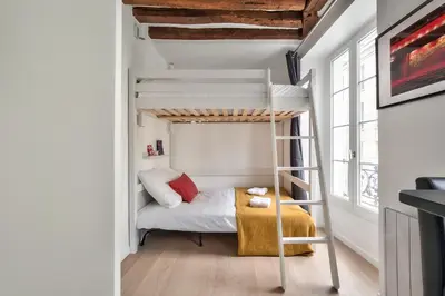 Un ou plusieurs lits dans un hébergement de l'établissement Lovely Mezzanine Studio in the Heart of Paris 3M