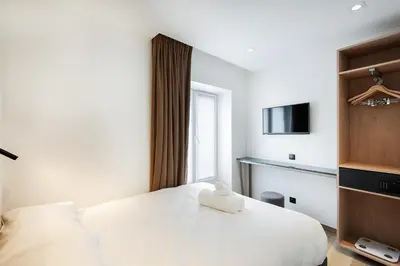 Un ou plusieurs lits dans un hébergement de l'établissement HOTEL AU COEUR DES ARTS ET METIERS