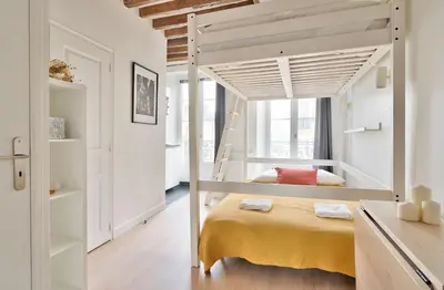 Un ou plusieurs lits dans un hébergement de l'établissement Stylish Mezzanine Studio in the Heart of Paris 3F