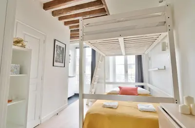 Un ou plusieurs lits dans un hébergement de l'établissement Stylish Mezzanine Studio in the Heart of Paris 3F