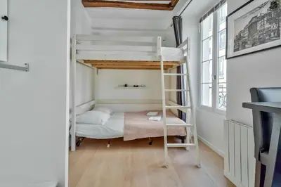 Un ou plusieurs lits dans un hébergement de l'établissement Cute Mezzanine Studio in the Heart of Paris (2M)
