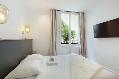 Un ou plusieurs lits dans un hébergement de l'établissement Apartment Palais Royal by Studio prestige
