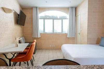 Un ou plusieurs lits dans un hébergement de l'établissement Appart Hôtel Résidence Courcelle
