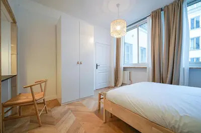 Un ou plusieurs lits dans un hébergement de l'établissement Parisuites Central Grands boulevards Chic Folies Bergères