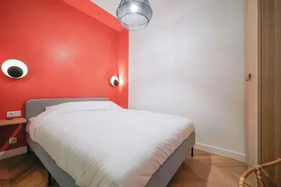 Un ou plusieurs lits dans un hébergement de l'établissement Parisuites Central Grands boulevards Chic Folies Bergères