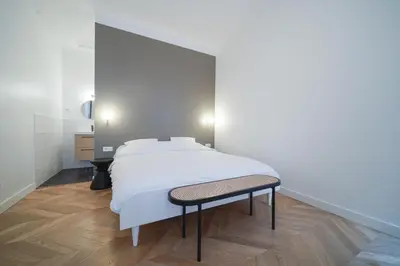 Un ou plusieurs lits dans un hébergement de l'établissement Parisuites Central Grands boulevards Design Folies Bergères