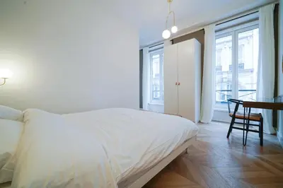 Un ou plusieurs lits dans un hébergement de l'établissement Parisuites Central Grands boulevards Design Folies Bergères