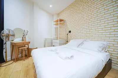Un ou plusieurs lits dans un hébergement de l'établissement Parisuites Central Canal Saint Martin Luxe & Chic & Cosy