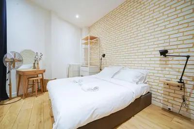 Un ou plusieurs lits dans un hébergement de l'établissement Parisuites Central Canal Saint Martin Luxe & Chic & Cosy