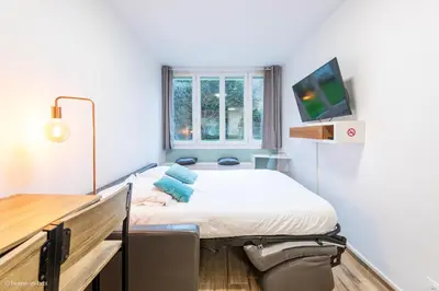 Un ou plusieurs lits dans un hébergement de l'établissement Studio Moderne au coeur de Paris