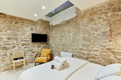 Télévision ou salle de divertissement dans l'établissement Residence Le Marais by Studio prestige