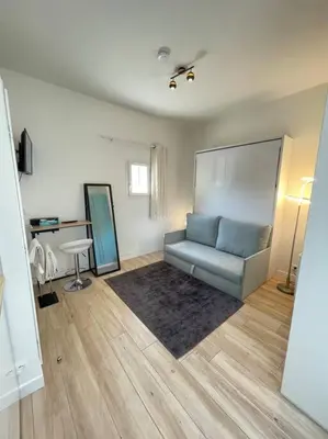 Coin salon dans l'établissement Studio Neuf, Meublé avec climatisation et parking payants