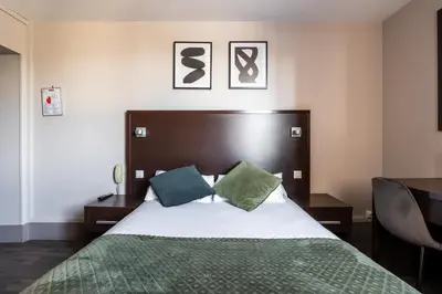 Un ou plusieurs lits dans un hébergement de l'établissement Hotel Bristol Nord Paris