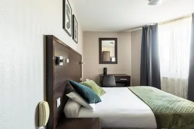 Un ou plusieurs lits dans un hébergement de l'établissement Hotel Bristol Nord Paris