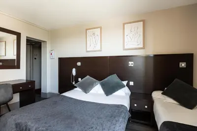 Un ou plusieurs lits dans un hébergement de l'établissement Hotel Bristol Nord Paris